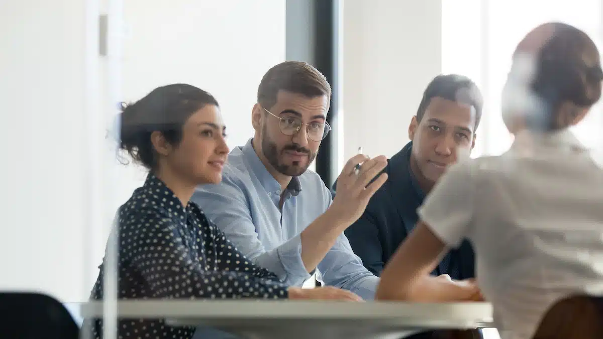 Une équipe efficace en formation interne au CSE, assise autour d'une table dans un bureau.