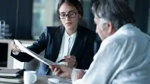 femme conseillère juridique expliquant documents à client senior en réunion bureau