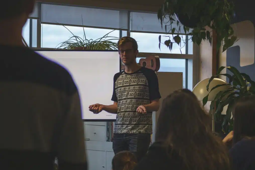 Un homme fait une présentation devant une association de personnes.