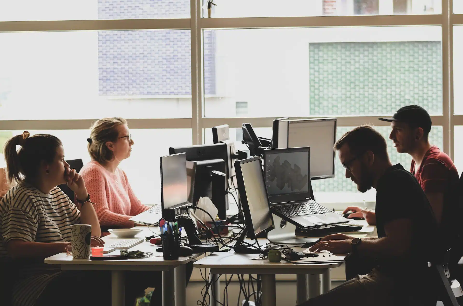 Un groupe de personnes travaillant sur des ordinateurs dans un bureau et formant une association.