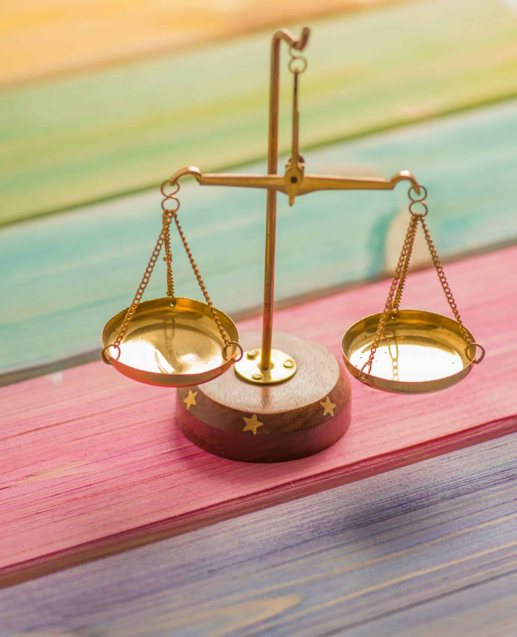 Une balance dorée reposant sur un fond en bois vibrant, mettant en valeur le thème de la subordination juridique.