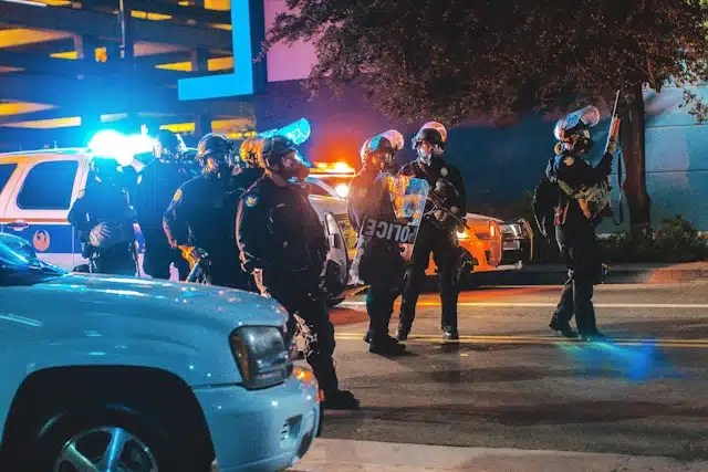 police en intervention nocturne sur une scène de crime avec véhicules et agents équipés