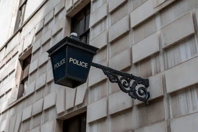 lanterne de police bleue accrochée à une façade de pierre grise
